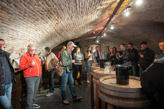Corporate group wine tasting in a historic cellar, showcasing a unique MICE venue in Bratislava for incentive events and team-building activities.