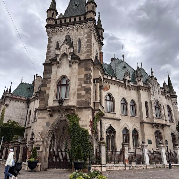 Historic Gothic-style Jakab Palace in Kosice with ornate tower, arched entrance, and decorative stonework under cloudy skies