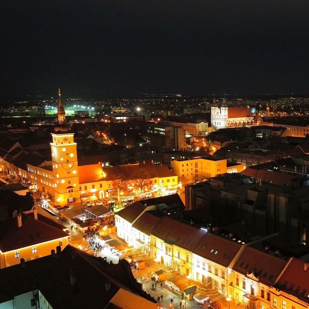 Aerial night view of Trnava Christmas market on Trinity Square, City Tower illuminated, Slovakia