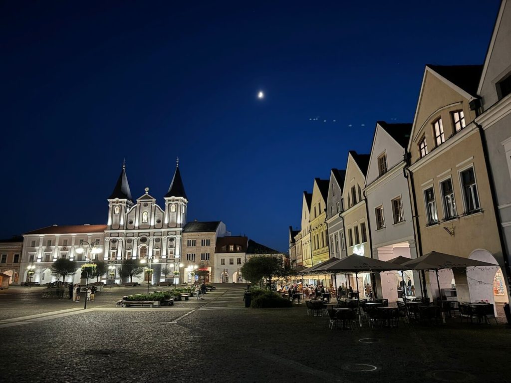 Night view of Žilina main square with church and cafes – things to do in Žilina