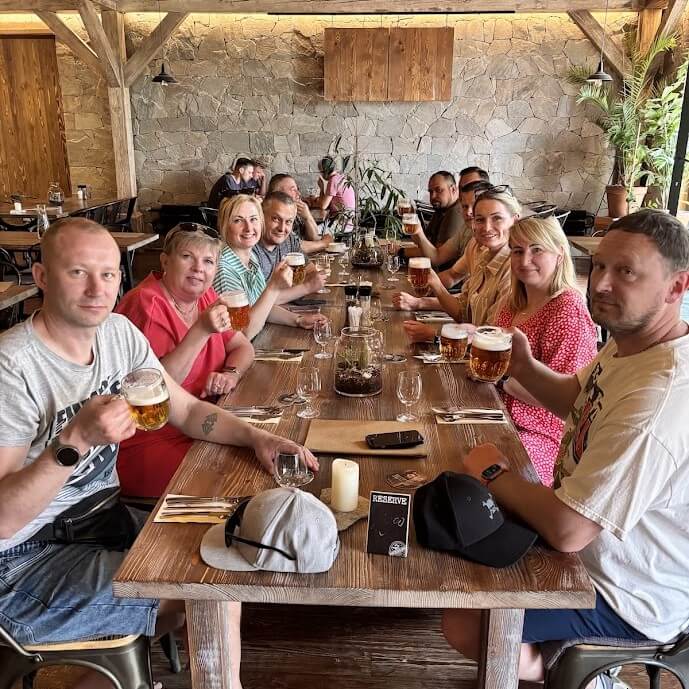 Tour group raising beer glasses at a traditional Slovak restaurant during a guided Bratislava city tour