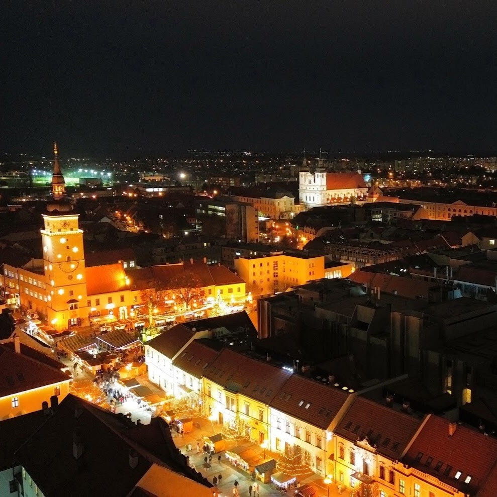Aerial night view of Trnava's illuminated historic centre and churches